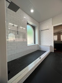 a bathroom with a black tile floor and a window